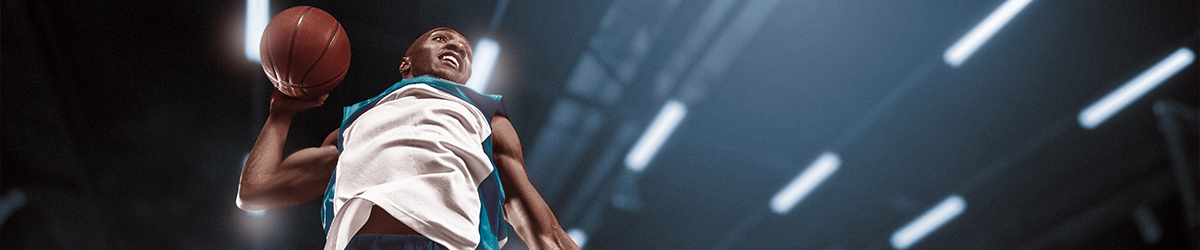 Basketball player on big professional arena during the game. Basketball player making slam dunk.