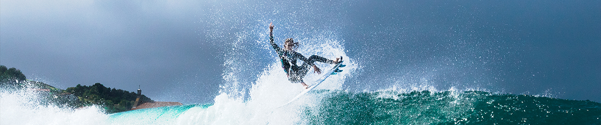 Surfer taking a picutre of his friend surfing the foamy wave of the ocean